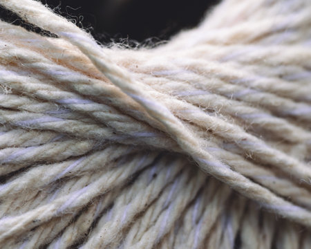 A closeup shot of white yarn for weaving against dark background