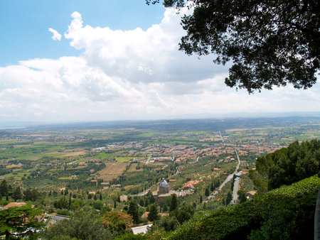 A high-angle shot of a green town or rural area with red roofs and dense treesの写真素材