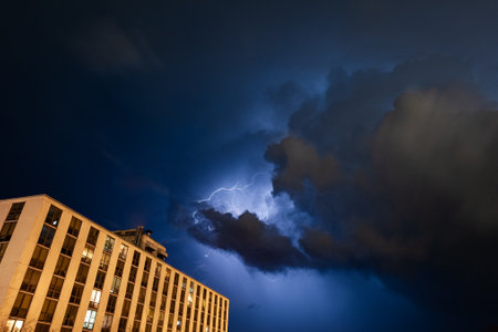 A low angle shot of the lightning storm with a building in the foregroundの写真素材
