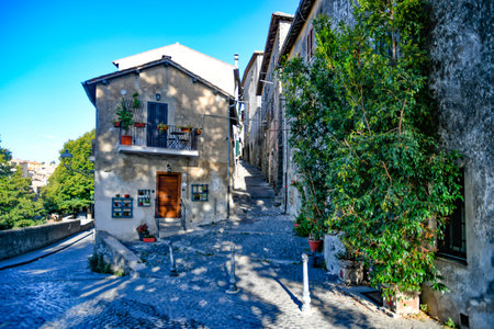 A narrow street passing through residential buildings on a sunny day in Bracciano, Lazio in Italyの写真素材