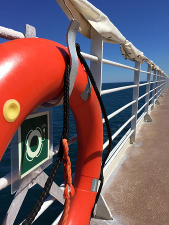 A orange lifebuoy with light on a railing of cruise ship.の写真素材