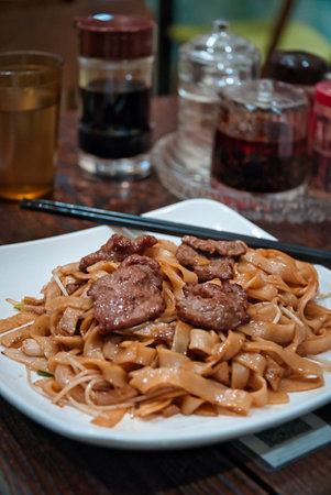 A vertical shot of noodles with beef in a Chinese restaurant.の写真素材