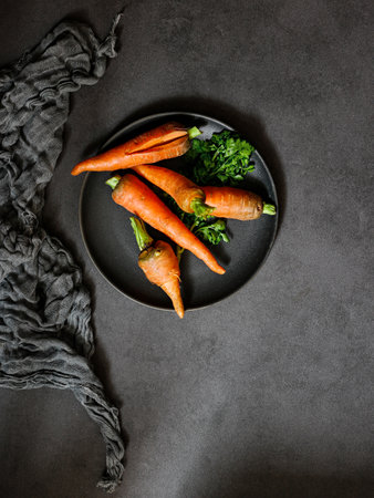 A top view of carrots on a black plate on a matte backgroundの写真素材