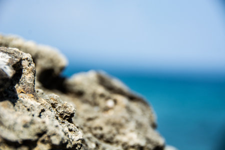 A selective focus shot of sharp rocks in the oceanの写真素材