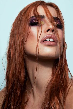 An attractive Australian female model wearing makeup with long hair covering parts of her face