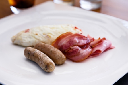 Breakfast dish include white egg omellete bacon and sausageの写真素材