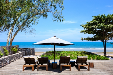 Wooden beach chairs with sun umbrellaの写真素材