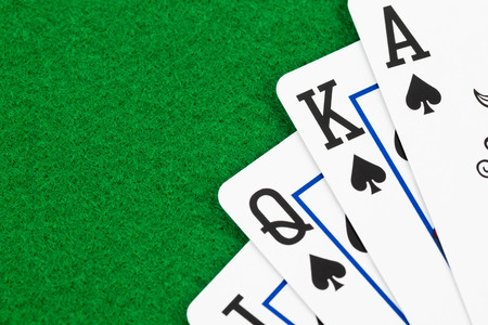 Royal flush poker playing cards on green felt