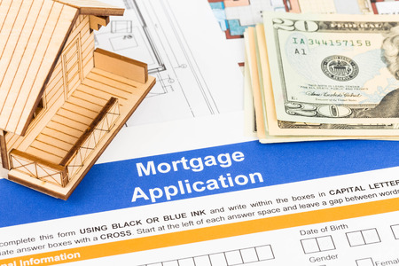 Mortgage application with model house, banknote, and drawingの写真素材