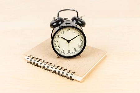 alarm clock on ring binder book or notebookの写真素材
