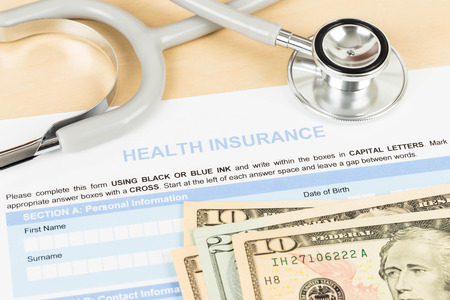 Health insurance application form with banknote and stethoscope concept for life planningの写真素材