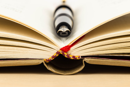 Fountain pen on middle of open bookの写真素材