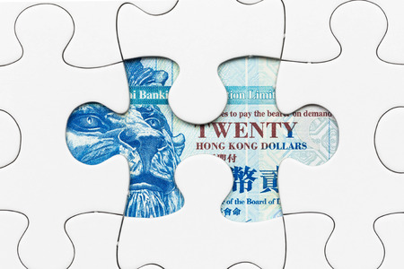 Hong Kong dollar banknote hidden under puzzle financial conceptの写真素材