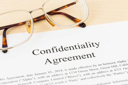 Confidentiality agreement document with glasses close-upの写真素材