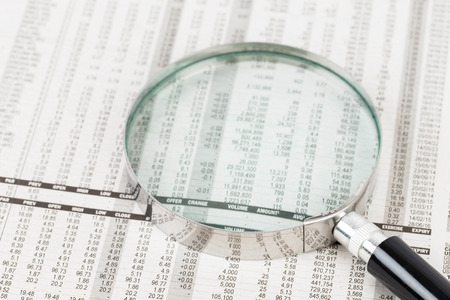 Magnifier rest on stock price detail financial newspaperの写真素材