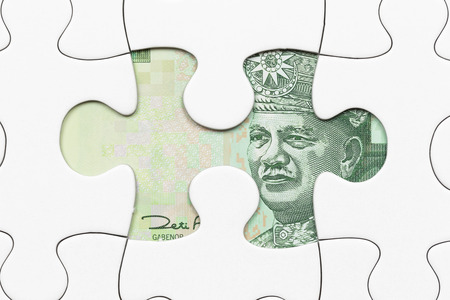 Malaysian ringgit banknote hidden under puzzle financial conceptの写真素材