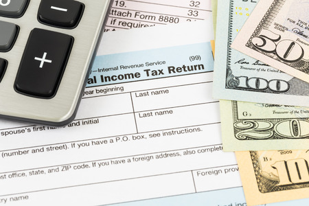 Tax form with calculator and banknote taxation concept