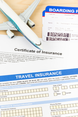 Travel insurance application form with plane model and boarding passの写真素材