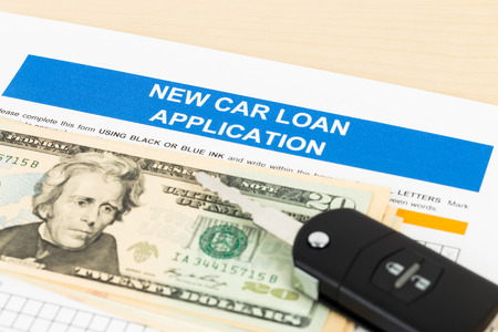 Car loan application with car key and dollar banknote; document is mock-upの写真素材