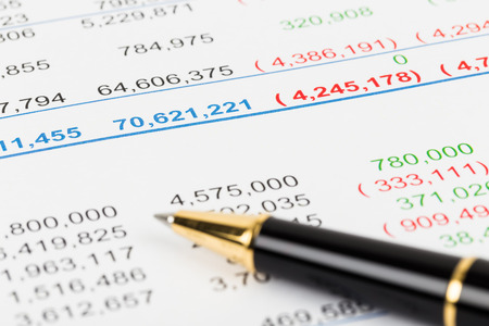 Financial Statement report focus on pen; document is mock-up