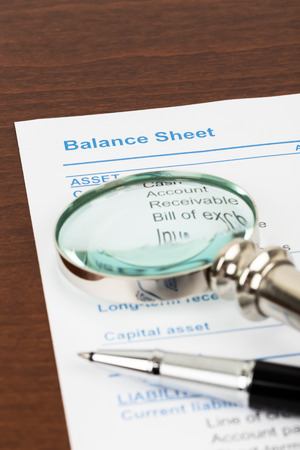Balance Sheet report with pen and magnifier document is mockupの写真素材