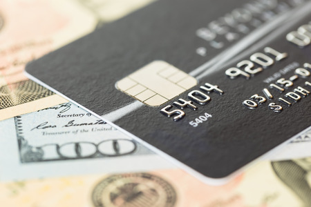 Black credit card on dollar banknote