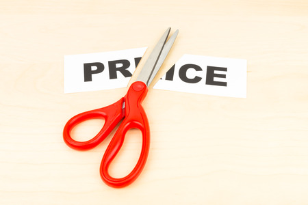 Price in paper cut by scissor on wooden desk concept price cutの写真素材