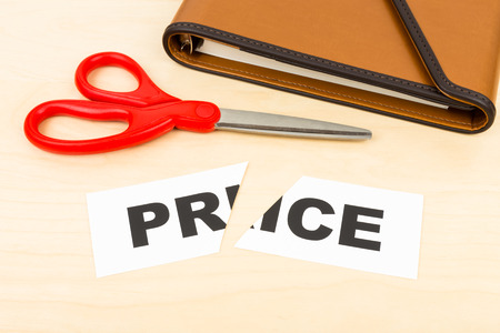 Price in paper cut by scissor on wooden desk concept price cutの写真素材