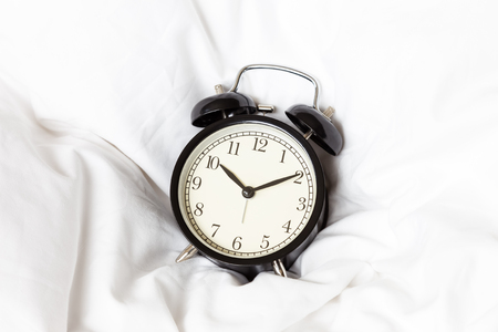 Alarm clock on white blanketの写真素材