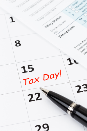 Tax day on calendar with pen, and tax formの写真素材