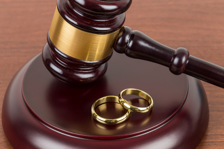 Wooden judge gavel and golden rings divorce conceptの写真素材