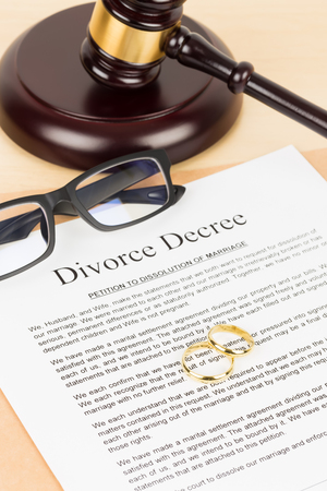 Wooden judge gavel, golden rings, and divorce decree; document is mock-upの写真素材