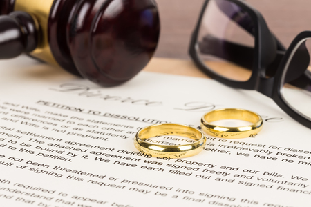 Wooden judge gavel, golden rings, and divorce decree; document is mock-upの写真素材