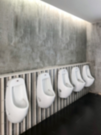 Blur abstract men toilet urinals in a public restroom loft style