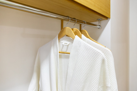 White elegance bathrobe hanging in wardrobeの写真素材