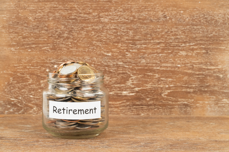 Money coin jar on wooden background retirement saving conceptの写真素材