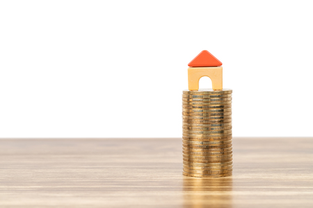Mini model house on coins stack concept for mortgage, finance, and savingの写真素材