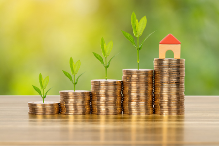 Mini model house on coins stack concept for mortgage, finance, and savingの写真素材