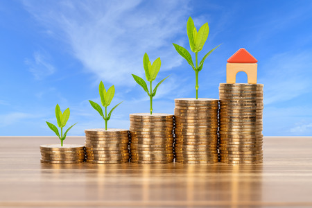 Mini model house on coins stack concept for mortgage, finance, and saving