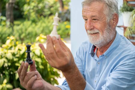 Elderly playing chess in nursing home for leisureの写真素材