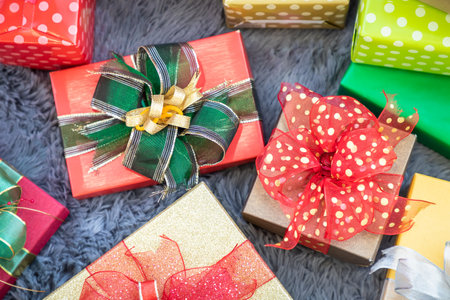 Stack of present gift box for Christmas with on grey shaggy fur carpet background