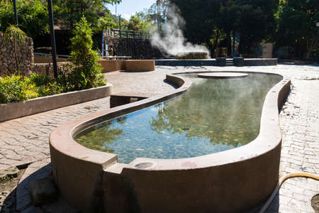 Ranong, Thailand - February 19, 2019: Famous hot spring well, and foot and leg plunge pond in Raksa Warin public park.のeditorial素材