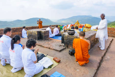 Rajgir, Bihar, India - October 13, 2018: Buddhist pilgrims and monk praying at Gandhakuti or...