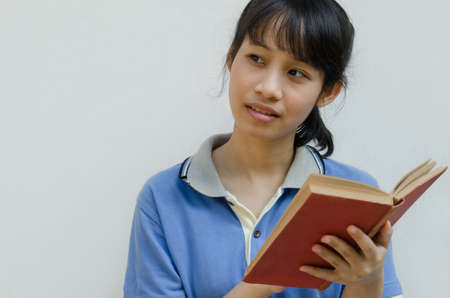 Asian Teenager Girl Thinking When Reading a Book.の写真素材
