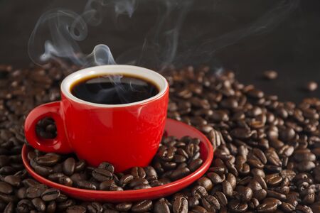 Smoke and red coffee cups on the old table on a black backgroundの写真素材