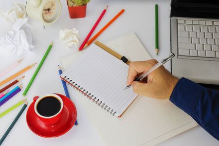 Red coffee cup with black coffee placed on the work desk A male employee sitting at workの写真素材