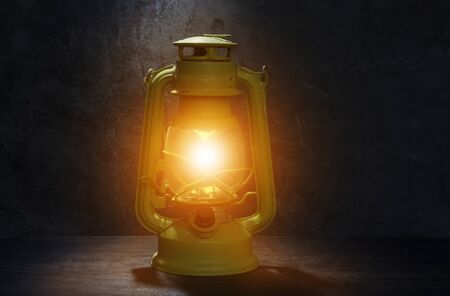 Old green kerosene lamp Laid on the old wooden floor with orange lights