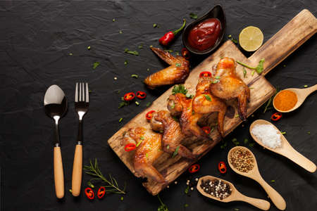Baked or Grilled Chicken Wings Where the chef cooks meticulously appetizing with spoons and forks...