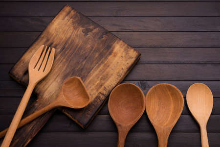 Kitchen utensils cutting board Wooden spoon and fork on the old black wooden floor top viewの写真素材
