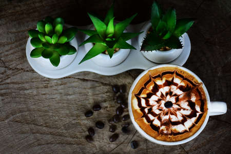 Cappuccino coffee cup with latte art on wooden floorの写真素材